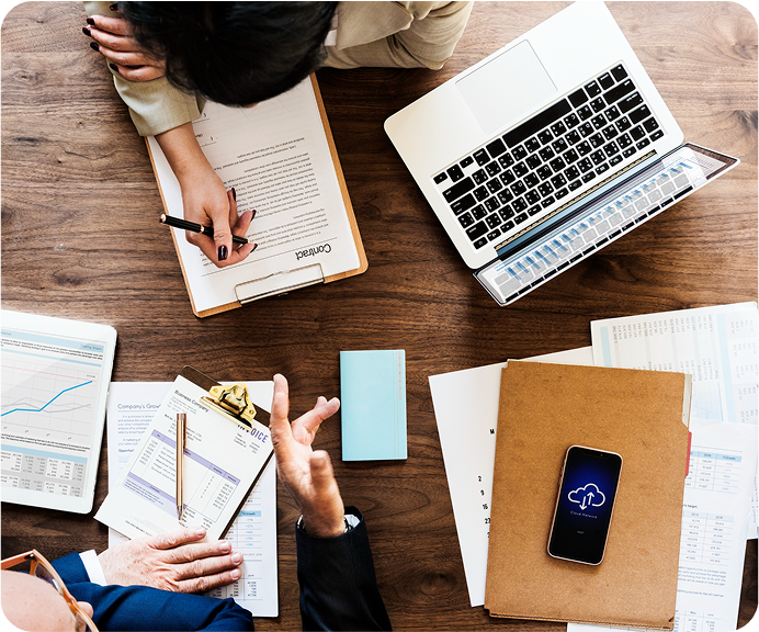 People collaborating over documents and a laptop